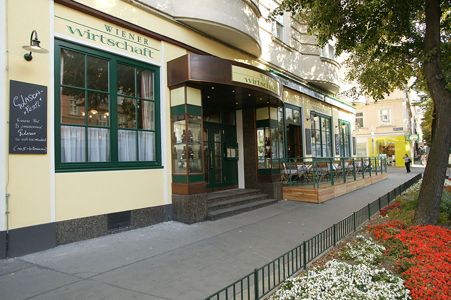 Der Schanigarten der Wiener Wirtschaft mit mehreren Stühlen und gedeckten Tischen